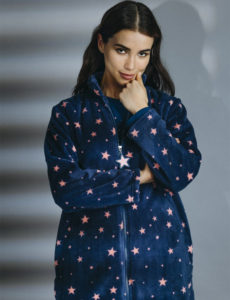 Mujer con pose confidente vistiendo una chaqueta azul decorada con estrellas brillantes
